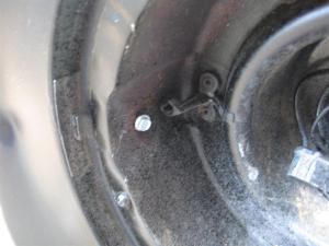 Screw located opposite spring side. 